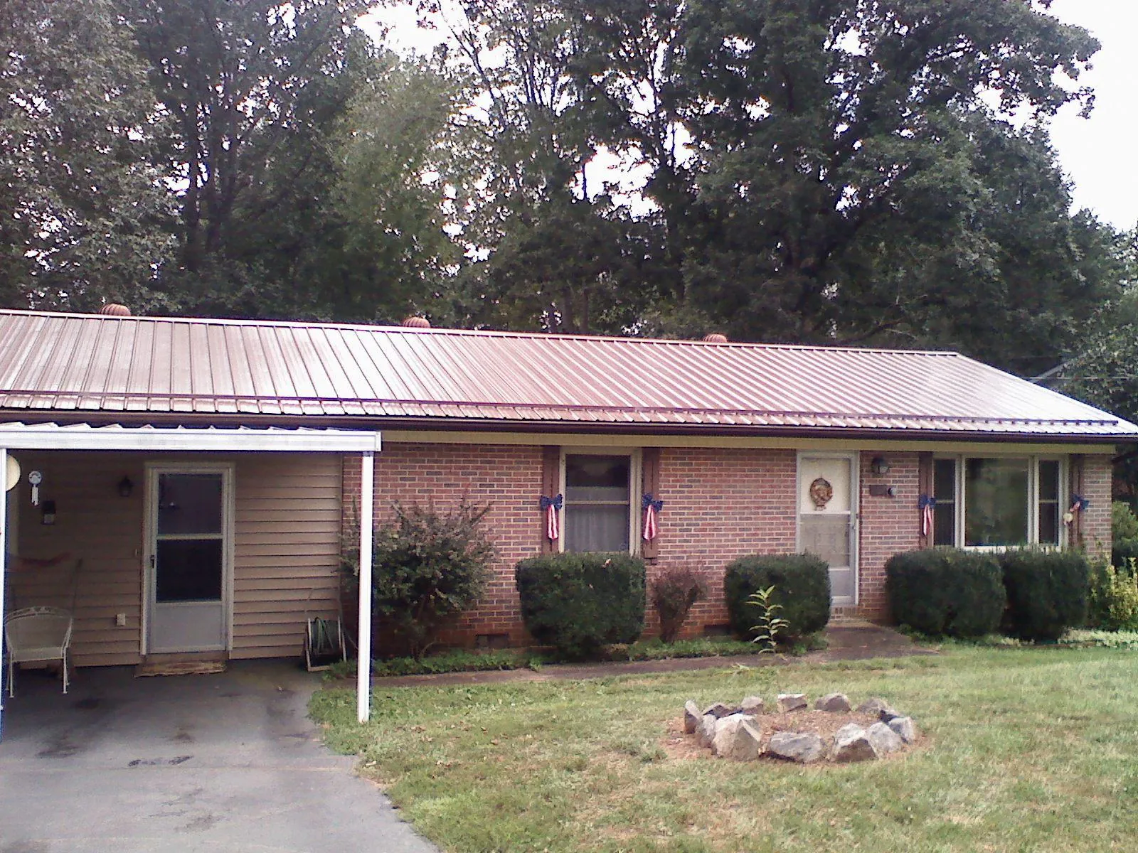 Bronze metal roof and carport on a brick ranch home — Roof Repair work by our crew in West Olive